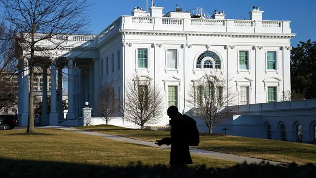 epa11887107 A journalist passes the White House, Washington, DC, USA, 10 February 2025. US President Donald Trump has announced the US will impose 25% tariffs on all steel and aluminum imports. EPA/WILL OLIVER