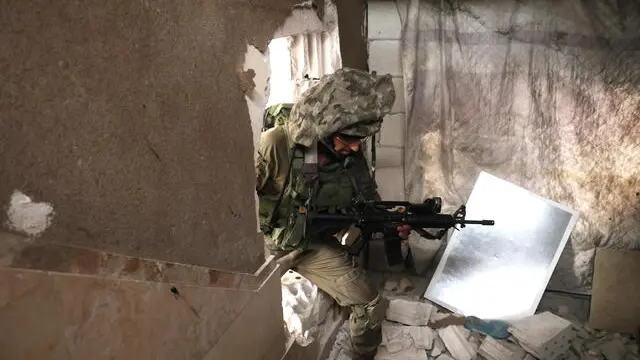 epa10966327 Israeli paratroopers undertake a training exercise ahead of deployment to Gaza in an abandoned house in Bat Yam, Israel, 09 November 2023. More than 10,500 Palestinians and at least 1,400 Israelis have been killed, according to the Israel Defense Forces (IDF) and the Palestinian health authority, since Hamas militants launched an attack against Israel from the Gaza Strip on 07 October, and the Israeli operations in Gaza and the West Bank which followed it. EPA/NEIL HALL