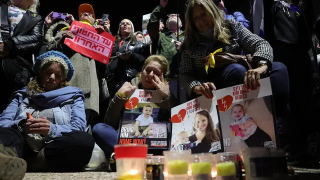 epa11910617 People gather to light candles at Hostages Square after the release of the bodies of four Israeli hostages held in Gaza, in Tel Aviv, Israel, 20 February 2025. Hamas was to hand over the bodies of four Israeli captives, including that of youngest hostage Kfir Bibas, as part of the ongoing Gaza ceasefire deal. Hamas said in November 2023 that the two Bibas boys and their mother had been killed in an Israeli airstrike on Gaza. EPA/ABIR SULTAN