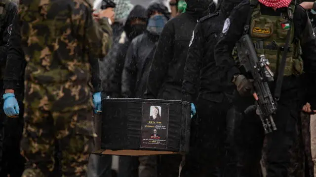 epa11909257 Palestinian fighters carry a coffin containing the body of Sheri Bibas before handing it over to the Red Cross in Khan Yunis, southern Gaza Strip, 20 February 2025. Hamas was set to hand over the bodies of four Israeli captives, including that of youngest hostage Kfir Bibas, as part of the ongoing Gaza ceasefire deal. Hamas said in November 2023 that the two Bibas boys and their mother had been killed in an Israeli airstrike on Gaza. EPA/HAITHAM IMAD
