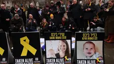 epa11910572 Photographs depicting Israeli hostages Shiri and Kfir Bibas are displayed during a vigil to mourn the dead Israeli hostages returned by Hamas to Israel, at Westminster in London, Britain, 20 February 2025. Hamas on 20 February handed over the bodies of four Israeli captives, including that of youngest hostage Kfir Bibas, as part of the ongoing Gaza ceasefire deal. Hamas said in November 2023 that the two Bibas boys and their mother had been killed in an Israeli airstrike on Gaza. EPA/ANDY RAIN