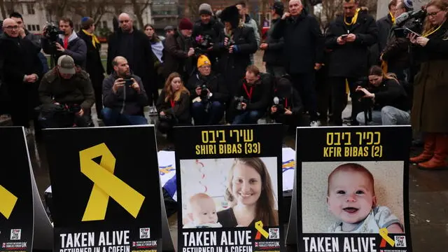 epa11910572 Photographs depicting Israeli hostages Shiri and Kfir Bibas are displayed during a vigil to mourn the dead Israeli hostages returned by Hamas to Israel, at Westminster in London, Britain, 20 February 2025. Hamas on 20 February handed over the bodies of four Israeli captives, including that of youngest hostage Kfir Bibas, as part of the ongoing Gaza ceasefire deal. Hamas said in November 2023 that the two Bibas boys and their mother had been killed in an Israeli airstrike on Gaza. EPA/ANDY RAIN