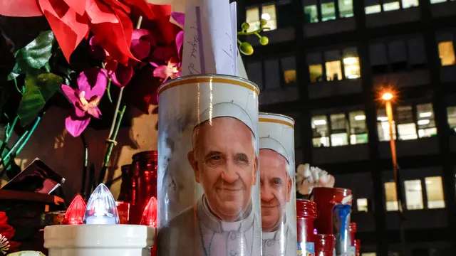 Candles with the pictures of Pope Francis are the laid under the statue of late Pope John Paul II outside Agostino Gemelli Hospital where Pope Francis is hospitalized to continues his treatments for bilateral pneumonia, in Rome, Italy, 21 February 2025. ANSA/GIUSEPPE LAMI