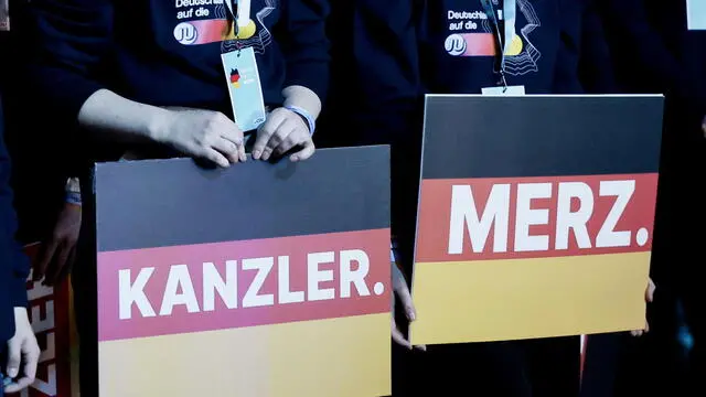 epa11913786 Supporters hold placards reading 'Chancellor Merz', during the Christian Democratic Union (CDU) election campaign event in Oberhausen, Germany, 21 February 2025. Germany will hold early federal elections on 23 February 2025 to elect a new Bundestag (parliament). EPA/RONALD WITTEK