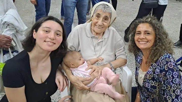Suor Saveria Menni, sorridente, con due fedeli e una bambina