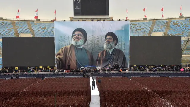 epa11914830 A banner featuring the portraits of late Hezbollah leaders Hassan Nasrallah and Hashem Safieddine hangs in the background as workers complete preparations ahead of their funeral ceremony at Beirut Sports City in Beirut, Lebanon, 22 February 2025. The funeral of Nasrallah and Safieddine will be held at the Beirut Sports City on 23 February, about five months after they were killed in separate Israeli strikes. EPA/WAEL HAMZEH