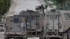 epa11912735 Israeli army vehicles block a road during a military operation at the Tulkarem refugee camp, in the West Bank city of Tulkarem, 21 February 2025. According to Palestinian news agency Wafa, Israeli forces have been conducting a nearly month-long operation in Tulkarem and its camps. The United Nations Children's Fund (UNICEF) reported at least 13 Palestinian children killed in the West Bank since the beginning of 2025. EPA/ALAA BADARNEH