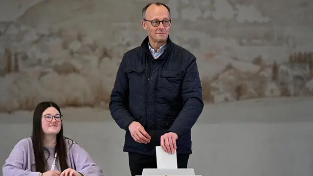 epaselect epa11917766 Chairman of the Christian Democratic Union (CDU) party and chancellor candidate Friedrich Merz (C) casts his vote for the general election, at a polling station in Arnsberg, Germany, 23 February 2025. About 60 million people are eligible to vote in the German elections for a new federal parliament, the 21st Bundestag. EPA/FABIAN STRAUCH