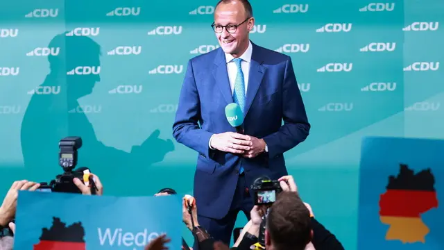 epa11919808 Chairman of Germany's Christian Democratic Union (CDU) Friedrich Merz reacts as the shadow of State Premier of Bavaria and Christian Social Union (CSU) chairman Markus Soeder is seen at the background during the Christian Democratic Union (CDU) election event in Berlin, Germany, 23 February 2025. EPA/HANNIBAL HANSCHKE