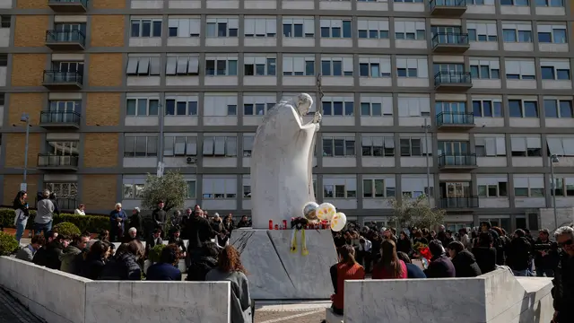 People pray under the statue of late Pope John Paul II outside Agostino Gemelli Hospital where Pope Francis is hospitalized to continues his treatments for bilateral pneumonia, in Rome, Italy, 23 February 2025. ANSA/GIUSEPPE LAMI