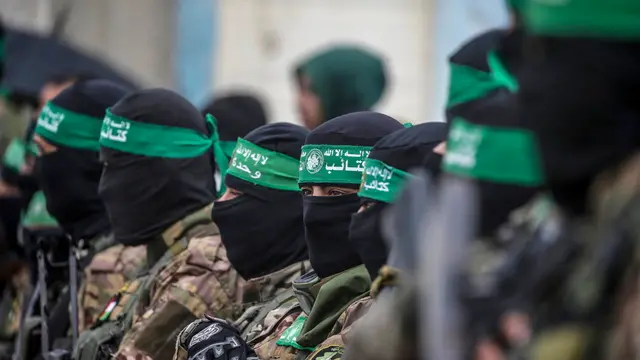 epa11915750 Armed fighters from Hamas' Izz ad-Din al-Qassam Brigades stand guard during the handover of three Israeli hostages to Red Cross representatives in Al Nuseirat refugee camp, central Gaza Strip, 22 February 2025. Six Israeli hostages were released on 22 February -- three in Nuseirat, two in Rafah and one in Gaza City -- after Hamas handed them over to the Red Cross in Gaza as part of the first phase of the Israel-Hamas ceasefire deal. EPA/MOHAMMED SABER