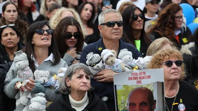 epa11914800 People watch the release of Israeli hostages Avera Mengistu and Tal Shoham on a big screen at Hostages Square in Tel Aviv, Israel, 22 February 2025. Four more hostages are also expected to be released in Nuseirat in central Gaza, in the final part of the first phase of the Israel-Hamas ceasefire deal. EPA/ABIR SULTAN