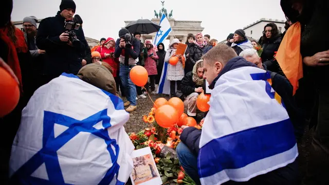 epaselect epa11925915 Participants place candles, flowers and orange balloons, during a protest in front of the Brandenburg Gate in Berlin, Germany, 26 February 2025. The protest was held to honor the lives of killed Israeli hostages of the family Bibas and to protest against Hamas terror. The bodies of four Israeli hostages, including those of Shiri Bibas and her young sons Ariel and Kfir, were returned to Israel on 20 February as part of the ongoing Gaza ceasefire deal between Israel and Hamas. EPA/CLEMENS BILAN