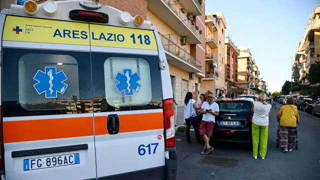 Un’ambulanza davanti alla palazzina dove è stata uccisa una donna a Roma, 4 agosto 2023. ANSA/RICCARDO ANTIMIANI