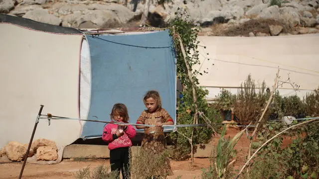 epa11659207 Displaced children stand at a camp of Internally Displaced People (IDP) at Ma'arrat Misrin, Idlib, northwest Syria, 14 October 2024. Carden arrived in northwest Syria to inspect camps of displaced Syrians, the distribution of food aid provided by the WFP and meet with Syrians who fled the hostilities in Lebanon amid the conflict between Israel and Hezbollah. According to the UNHCR on 14 October, a total of approximately 276,000 people (both Lebanese and Syrians) are estimated to have crossed from Lebanon to Syria since the escalation of hostilities in Lebanon. At least 21,000 Syrians fleeing the conflict in Lebanon arrived at north-east Syria and around 3,000 have arrived in north-west Syria, UNHCR stated. EPA/BILAL AL HAMMOUD