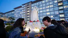 Faithful pray in front the statue of John Paul II at the entrance to the Gemelli Hospital, where Pope Francis is hospitalized, in Rome, Italy, 28 February 2025. Pope Francis was admitted to the Agostino Gemelli Hospital in Rome on February 14 due to a respiratory tract infection. ANSA/FABIO FRUSTACI