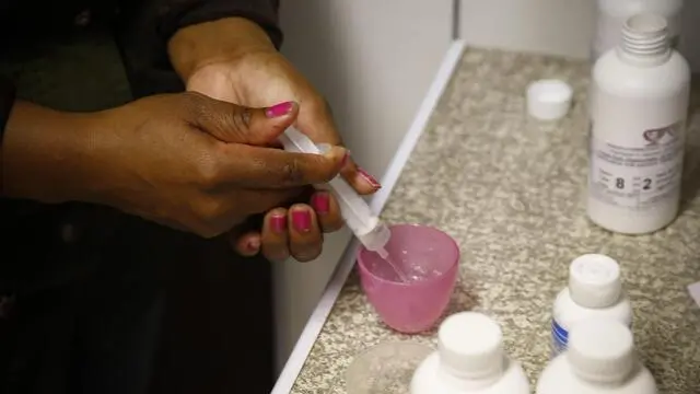 epa05432408 South African Child Care worker Nobanzi Somtsewu prepares the daily routine of Antiretroviral (ARV) medicines for children at the HOKISA childrens home in Masiphumelele, Cape Town, South Africa 19 July 2016. HOKISA stands for Homes For Kids In South Africa where children living with and affected by HIV and AIDS are cared for. When a child cannot be looked after by family members or neighbours, he or she is placed via the Magistrates Court at the HOKISA home. South Africa is currently hosting the 2016 International Aids Conference between 18-22 July which is attented globally by over 18 000 delegates, policy makers, HIV Workers as well as many living with HIV. South Africa has the biggest and most high profile HIV epidemic in the world, with an estimated 6.5 million people living with HIV. Over 2.5 million children in South Africa have been orphaned by HIV and AIDS and over 400,000 children aged 0 to 14 are living with HIV in South Africa. EPA/NIC BOTHMA