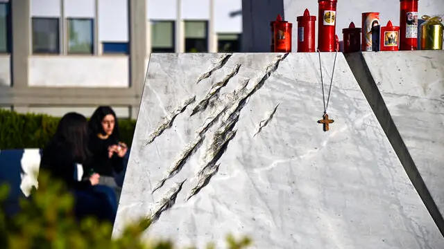 Candles and crucifix at the base of the statue of Pope John Paul II at the entrance to the Gemelli Hospital, where Pope Francis is hospitalized, Rome, 03 March 2025. ANSA/RICCARDO ANTIMIANI