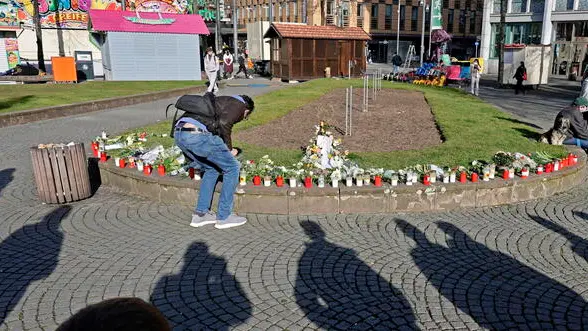 epa11939920 Flowers and candles are placed at the crime scene in Mannheim, Germany, 04 March 2025, where a vehicle drove into pedestrians on 03 March 2025. According to statements from police, a vehicle drove into a crowd in the Mannheim city center, killing two people and injuring ten others. EPA/RONALD WITTEK