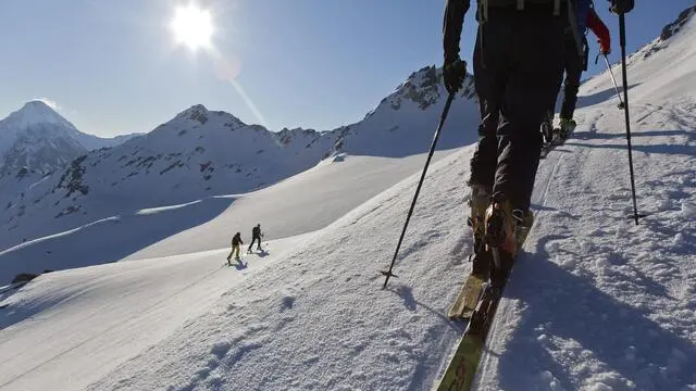 epa03206391 A group of skiers practice ski touring in front of the Flueela-Wisshorn, near Davos, Switzerland, on 04 May 2012. EPA/ARNO BALZARINI