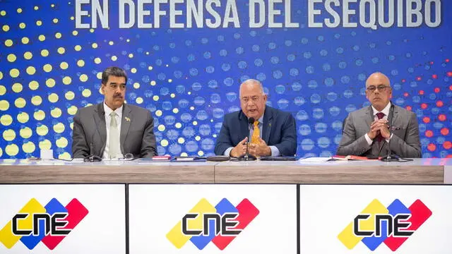 epa11010959 Venezuelan President Nicolas Maduro (L) and the President of the Venzuelan National Assembly (AN) Jorge Rodriguez (R) listen to the President of National Electoral Council (CNE) Elvis Amoroso (C), during an event about the non-binding referendum in Caracas, Venezuela, 04 December 2023. The non-binding referendum on the territorial dispute with eastern neighbor Guyana saw a turnout of 2,110,864 voters out of 20.69 million citizens, an abstention of over 89 percent. The referendum included five questions. The first four were about the acceptance or rejection of international treaties and tribunals to settle the border issue with Guyana. EPA/Rayner Pena R