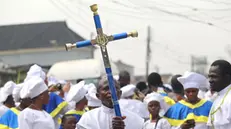 epaselect epa09882546 A worshipper holds a cross as members of the Celestial Church of Christ International headquarters observe a procession on Palm Sunday, in Lagos, Nigeria, 10 April 2022. Members of the Celestial Church of Christ International today joined their counterparts all over the world to celebrate Palm Sunday. Each armed with their palm fronds offering processional hymns, these Christians marched through the Ketu area of Lagos state singing and dancing, the ceremony they say symbolizes the entry of Jesus into Jerusalem. EPA/AKINTUNDE AKINLEYE
