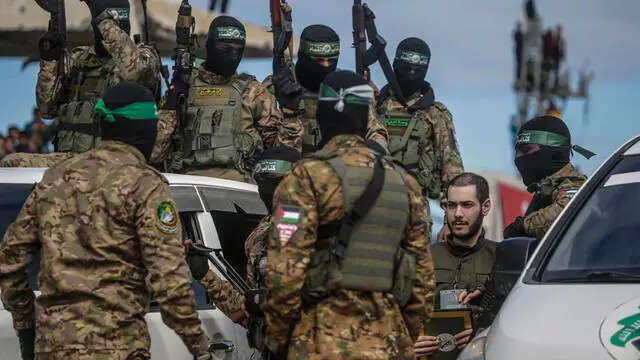 epa11915199 Fighters from Hamas' Izz ad-Din al-Qassam Brigades escort Israeli hostage Eliya Cohen before handing him over to the Red Cross in Al Nusairat refugee camp, central Gaza Strip, 22 February, 2025. Two further hostages were released earlier in the day in Rafah, southern Gaza Strip, in the final part of the first phase of the Israel-Hamas ceasefire deal. EPA/MOHAMMED SABER