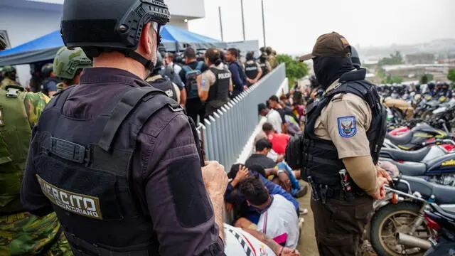 epa11908038 Members of the police and army stand guard next to a group of people detained after a security operation at Flor de Bastion neigborhood in Guayaquil, Ecuador, 19 February 2025. Some of the 1,000 members of Ecuador National Police and 400 of the Armed Forces were deployed to contain violence at one of the most critical area in the Guayas province, Southwestern of Ecuador. EPA/MAURICIO TORRES