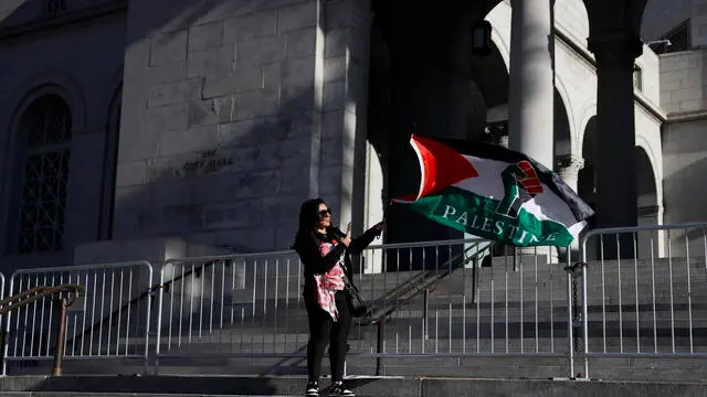 epa11840811 A person waves a flag in support of Palestine as people gather during the 'We Fight Back' rally outside of City Hall in Los Angeles, California, USA, 20 January 2025. People gathered to focus on workers' rights, immigrant rights, environmental justice, support for Palestine, victims of the Eaton and Palisades fires, protest billionaires and US President Donald Trump as he was sworn in for a second term as president of the United States on 20 January. EPA/CAROLINE BREHMAN