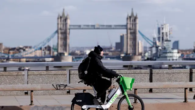 epa11923951 A person rides a Lime rental electric bike in central London, Britain, 25 February 2025. Westminster council will convert around 200 car parking spaces in central London into parking bays for dockless e-bikes in a bid to stop them being dumped on pavements. According to the council, up to 5,000 people a month are fined for failing to leave a Lime e-bike in a designated bay in Westminster alone. EPA/TOLGA AKMEN