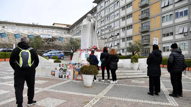 Alcune persone in preghiera per Papa Francesco davanti alla statua di Giovanni Paolo II nel piazzale del Policlinico Gemelli Roma, 08 marzo 2025 ANSA/FABIO CIMAGLIA