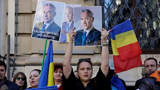 epa11952312 Calin Georgescu supporters wave placards and national flags while shouting slogans during a protest in front of the Central Elections Bureau in Bucharest, Romania, 09 March 2025. Georgescu, the independent candidate who won the first round of Romania's annulled presidential elections, registered his candidacy at the Central Elections Bureau on 07 March 2025. Former independent presidential candidate Georgescu was questioned by prosecutors on 26 February 2025 as part of an investigation into election campaign fraud, including actions against the constitutional order and false statements about campaign financing. A judge from the Prosecutor General's Office imposed a judicial control measure, which Georgescu appealed. Romanians will vote in the first round of the presidential elections on 4 May 2025. EPA/ROBERT GHEMENT