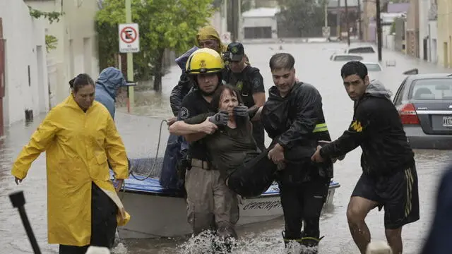 epa11947999 Emergency personnel assist a woman affected during a flood due to heavy rains, in Bahia Blanca, Argentina, 07 March 2025, following torrential rainfall of more than 200 millimeters in four hours. EPA/PABLO PRESTI