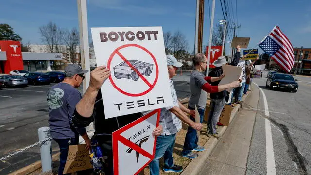 epa11949927 Demonstrators gather outside a Tesla dealership to protest businessman Elon Musk's current role in US President Donald Trump's administration in Decatur, Georgia, USA, 08 March 2025. Musk is leading the Department of Government Efficiency (DOGE) and has come under criticism for wide-scale government layoffs and downsizing. EPA/ERIK S. LESSER