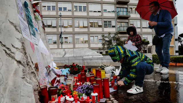 People pray under the statue of late Pope John Paul II outside Agostino Gemelli Hospital where Pope Francis is hospitalized to continues his treatments for bilateral pneumonia, in Rome, Italy, 12 March 2025. ANSA/GIUSEPPE LAMI