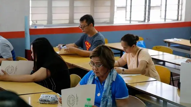 epa07566265 Detained Philippine Senator Leila De Lima (bottom) casts her vote at a precinct in Paranaque, south of Manila, Philippines, 13 May 2019. Over 61 million Filipinos are expected to cast their vote in the country's mid-term elections, wherein over 43,000 candidates are vying for some 18,000 electoral posts including seats in the Philippine Senate and House of Representatives. EPA/MARK R. CRISTINO