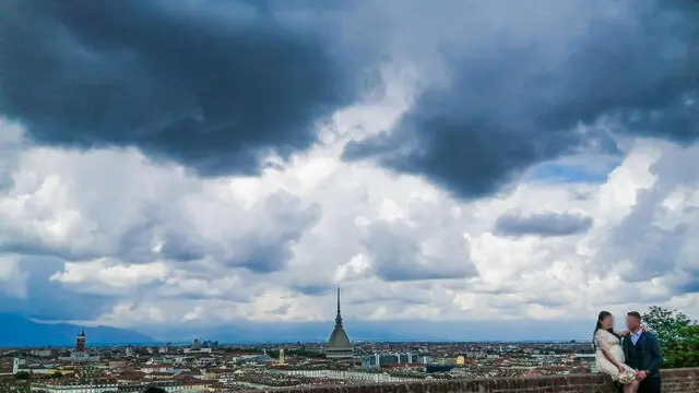 Nuvole nere minacciose di pioggia incombono sulla città e su una coppia di novelli sposi sul monte dei Cappuccini. Torino 14 maggio 2021 ANSA/TINO ROMANO
