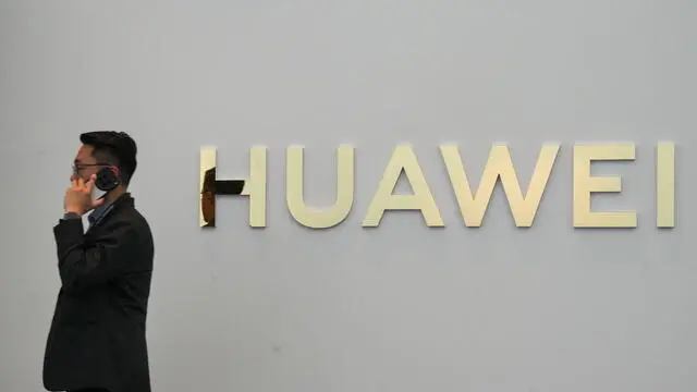 epa11904235 A man speaks on the phone near the Huawei logo during a product launch event in Kuala Lumpur, Malaysia, 18 February 2025. Chinese tech giant Huawei unveiled the Huawei Mate XT, the worldâ€™s first tri-fold smartphone for its international market, at the Kuala Lumpur launch. EPA/MUKHRIZ HAZIM