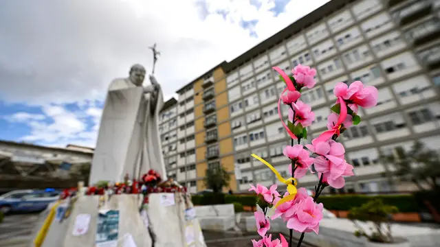 Flowers left by faithfuls in front of the statue of John Paul II at the entrance of Gemelli Hospital where Pope Francis is still hospitalized, Rome, Italy, 13 March 2025. ANSA/RICCARDO ANTIMIANI