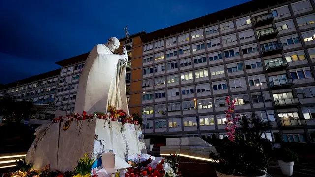 People leave candles and cards at the base of the statue of John Paul II at the entrance to the Gemelli Hospital, where Pope Francis is hospitalized, in Rome, Italy, 15 March 2025. ANSA/FABIO FRUSTACI