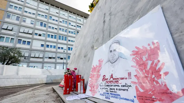 People leave candles and cards at the base of the statue of John Paul II at the entrance to the Gemelli Hospital, where Pope Francis is hospitalized, in Rome, Italy, 15 March 2025. ANSA/FABIO FRUSTACI