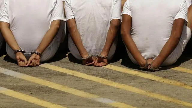 epa06172730 Policemen direct men to a high security prison, in San Salvador, El Salvador, 30 August 2017. A total of 35 members of criminal organizations, accused of murdering police and military personnel in El Salvador, were transferred to the maximum security prison in Zacatecoluca, where they will serve their sentences under a special detention regime. EPA/Rodrigo Sura