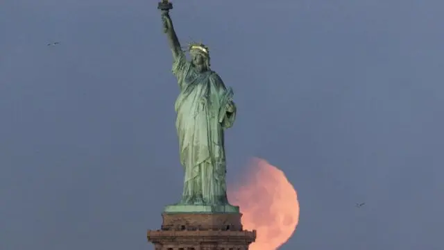 epa06487779 The moon sets behind the Statue of Liberty in New York, New York, USA, 31 January 2018. The moon is a supermoon, blue moon and total lunar eclipse that NASA has dubbed a 'Super Blue Blood Moon'. This is the last one in a series of three consecutive 'Supermoons', dubbed the 'Supermoon Trilogy'. The previous 'Supermoons' appeared on 03 December 2017 and on 01 January 2018. A 'Supermoon' commonly is described as a full moon at its closest distance to the earth with the moon appearing larger and brighter than usual. EPA/JUSTIN LANE