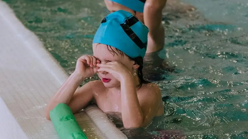 Bambini e bambine a un corso di nuoto