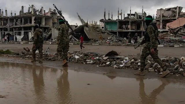 epa11914884 Palestinian fighters from Hamas Izz ad-Din al-Qassam Brigades walk after handing over two Israeli hostages to Red Cross representatives in Rafah, southern Gaza Strip, February 22, 2025. Four more hostages are expected to be released imminently in Nuseirat in central Gaza, in the final part of the first phase of the Israel-Hamas ceasefire deal. EPA/HAITHAM IMAD
