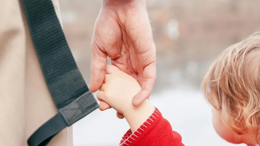 Un padre mano nella mano con la figlia