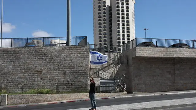 epa11973293 A man waves an Israeli flag during a protest in Jerusalem against Israeli Prime Minister Netanyahu's announced plans to dismiss Shin Bet chief Ronen Bar, 19 March 2025. EPA/ATEF SAFADI