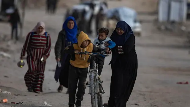 epa11976361 Displaced Palestinians carrying their belongings move towards the city center, in Gaza City, Gaza Strip, 20 March 2025, after the Israeli army issued evacuation orders for the northern areas of the city. EPA/HAITHAM IMAD