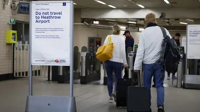 epa11978258 Passengers at Hatton Cross Underground station pass a notice advising people not to travel to Heathrow Airport in London, Britain, 21 March 2025. Heathrow Airport on 21 March announced it would be closed all day, following a power outage 'due to a fire at an electrical substation supplying the airport'. EPA/TOLGA AKMEN