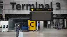 epa11977929 A passenger stands outside Terminal 3 at Heathrow Airport in Hillingdon, London, Britain, 21 March 2025. The Heathrow Airport on 21 March announced it would be closed all day, following a power outage 'due to a fire at an electrical substation supplying the airport'. EPA/TOLGA AKMEN